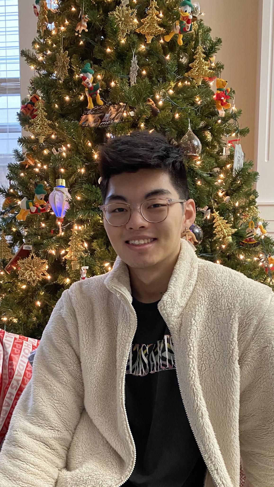 Eric Chung in front of a Christmas tree.