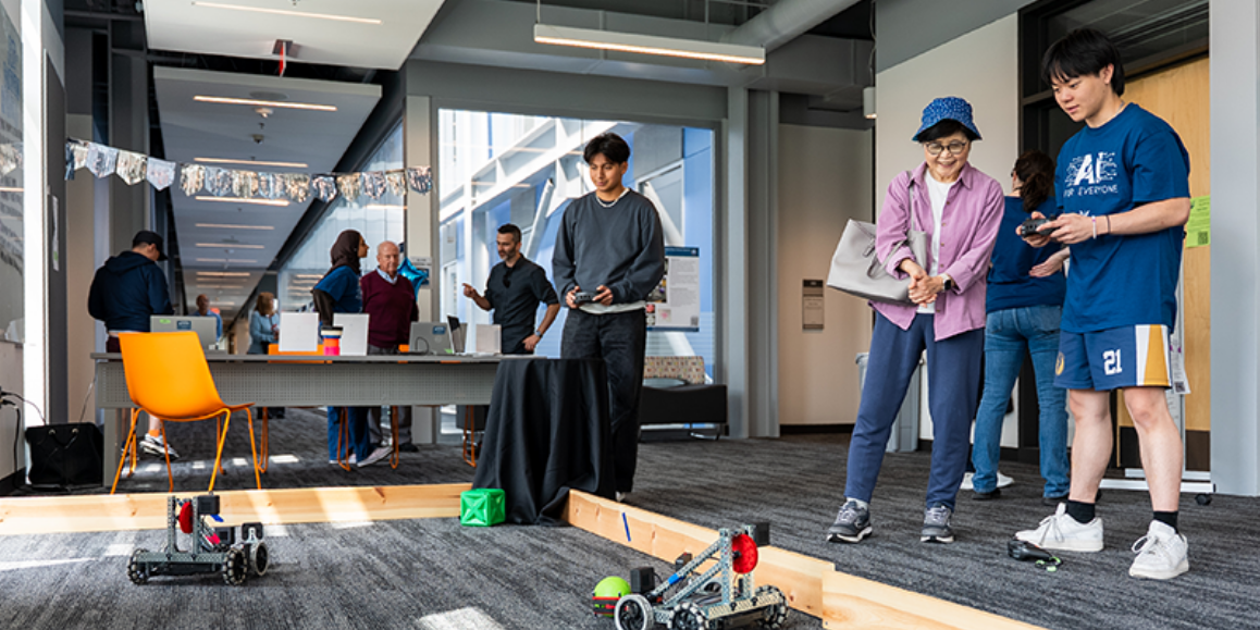 Students demonstrating the use of a robot at AI for Everyone Day
