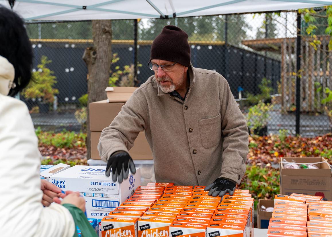 Stewart Sinning distributes boxes of stuffing during Edmonds College&rsquo;s Thanksgiving food giveaway. Along with electronics recycling and paper shredding, Edmonds College staff will accept non-perishable food and monetary donations for the food pantry on Saturday, March 14.  (Miranda Shook / Edmonds College)