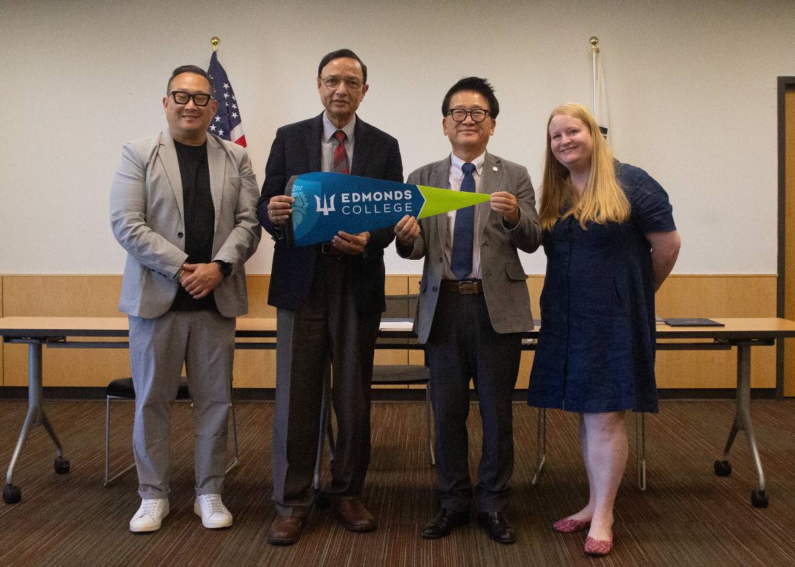 (L to R) GSKA Board Chair Sam Sim, Edmonds College President Dr. Amit B. Singh, GSKA President Won Jun Kim, and Executive Director of International Education Amanda Fletcher pose with an Edmonds College pennant after signing a Memorandum of Understanding (MOU). (photo by Vincent Vanhee / Edmonds College)