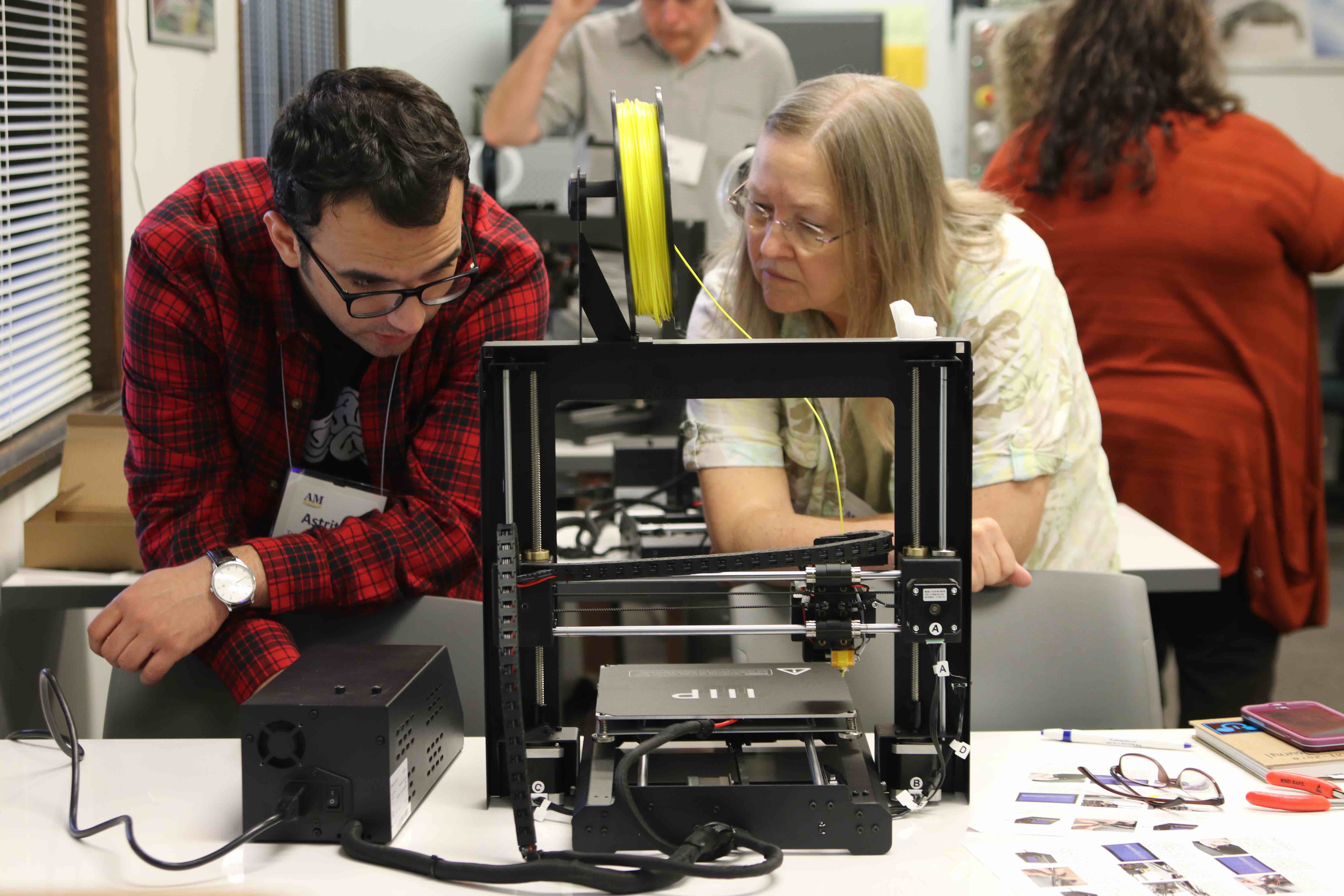 Astrit Imeri and Cathy Webb using a 3D printer