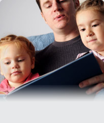 man reading a book to children