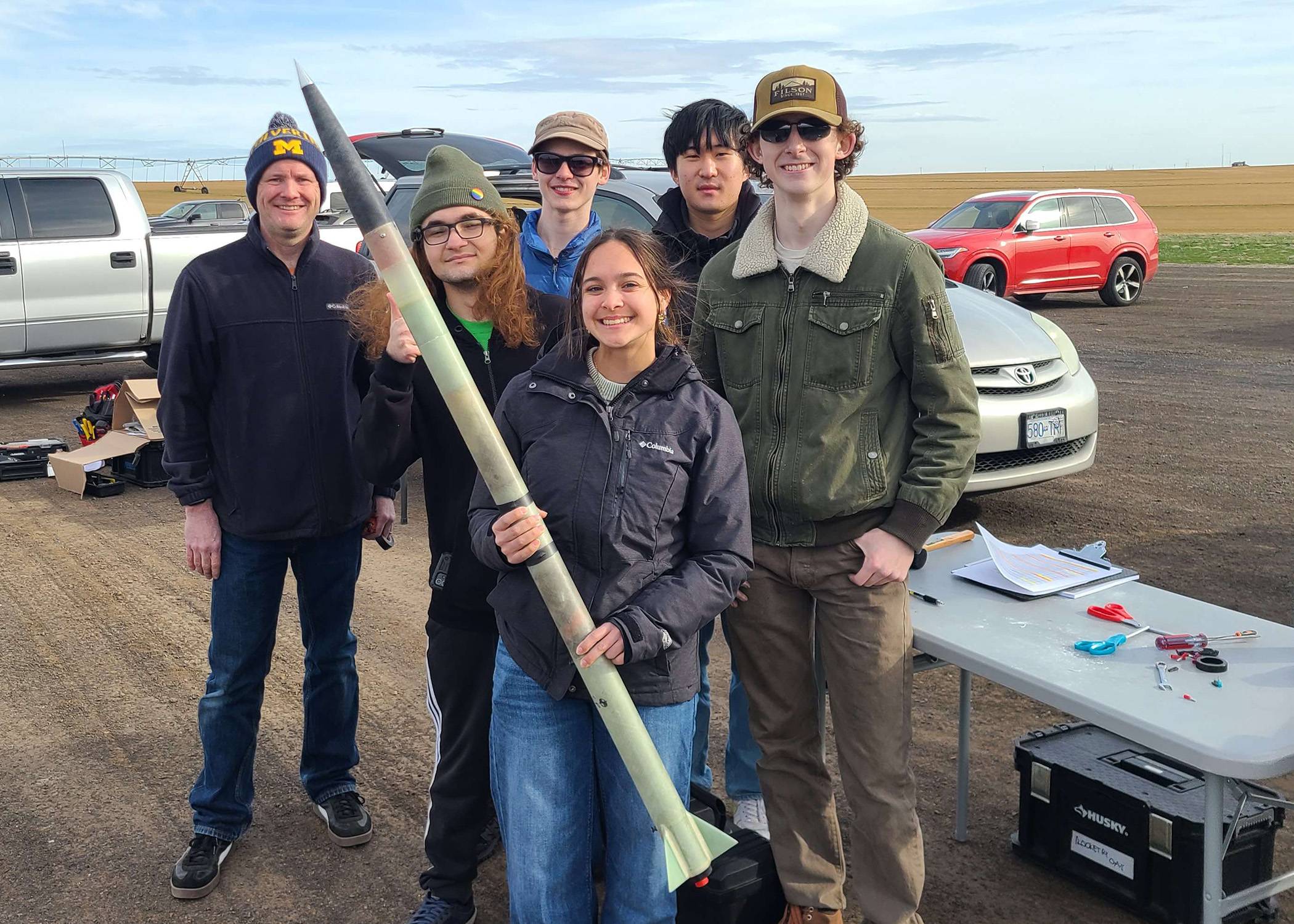 Emmalynn Kuenning holds a rocket during testing with her Edmonds College Rocketry Club teammates