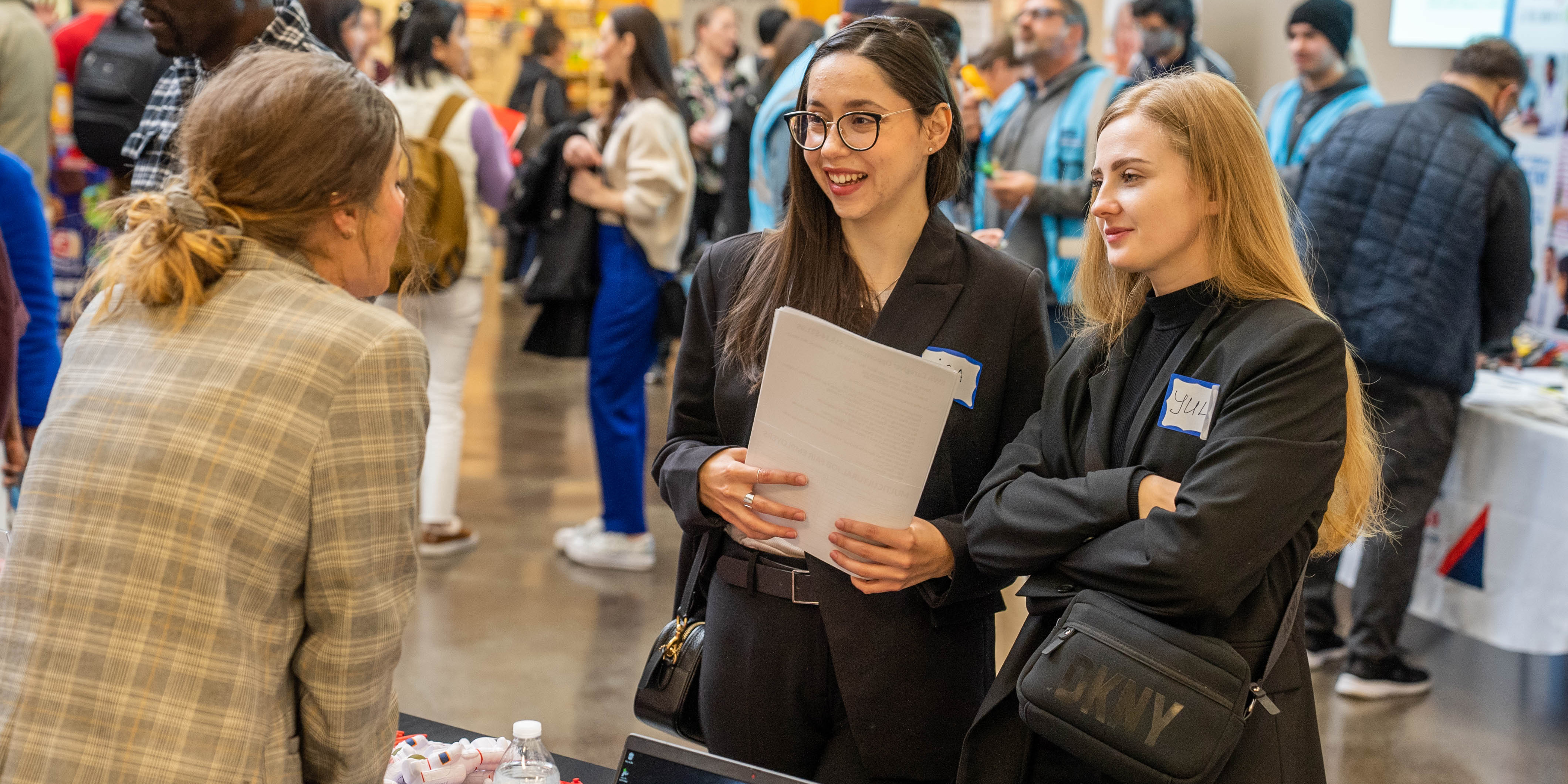 Two students at a table talking to a counselor.