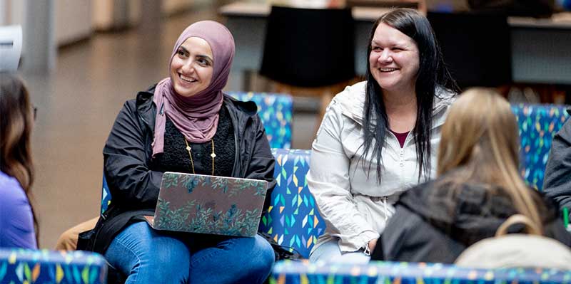 Two students in Hazel Miller looking to the left and smiling.