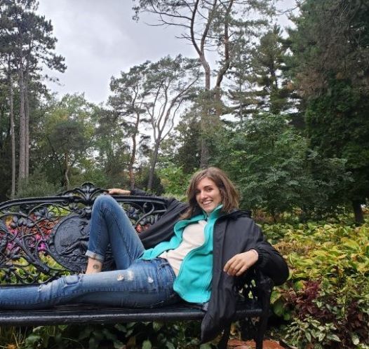 Picture of Ember hanging out on a bench located in a garden