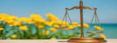 scales of justice with ocean background and yellow flowers