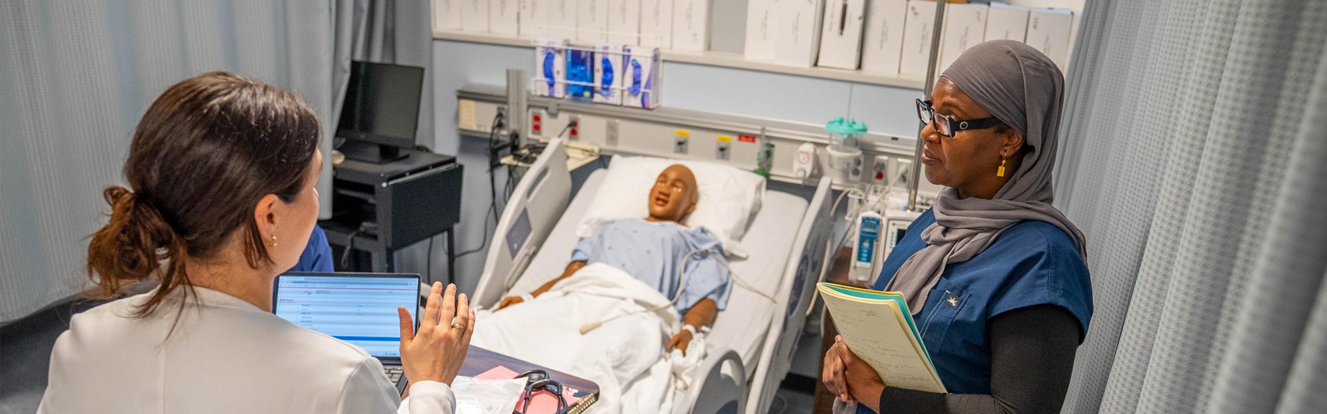 Nursing student talking to instructor in the simulation lab