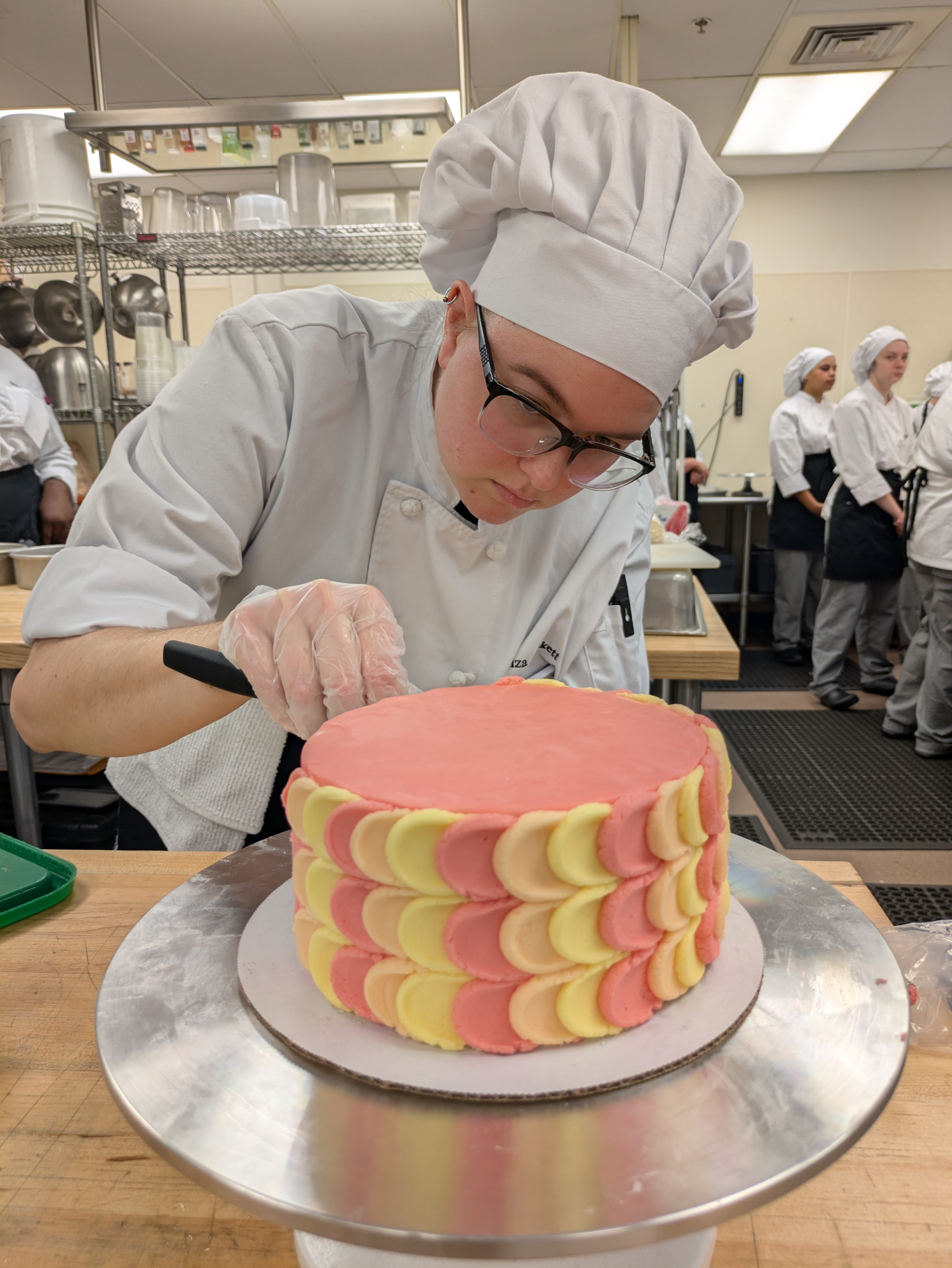 Student finalizing a cake.