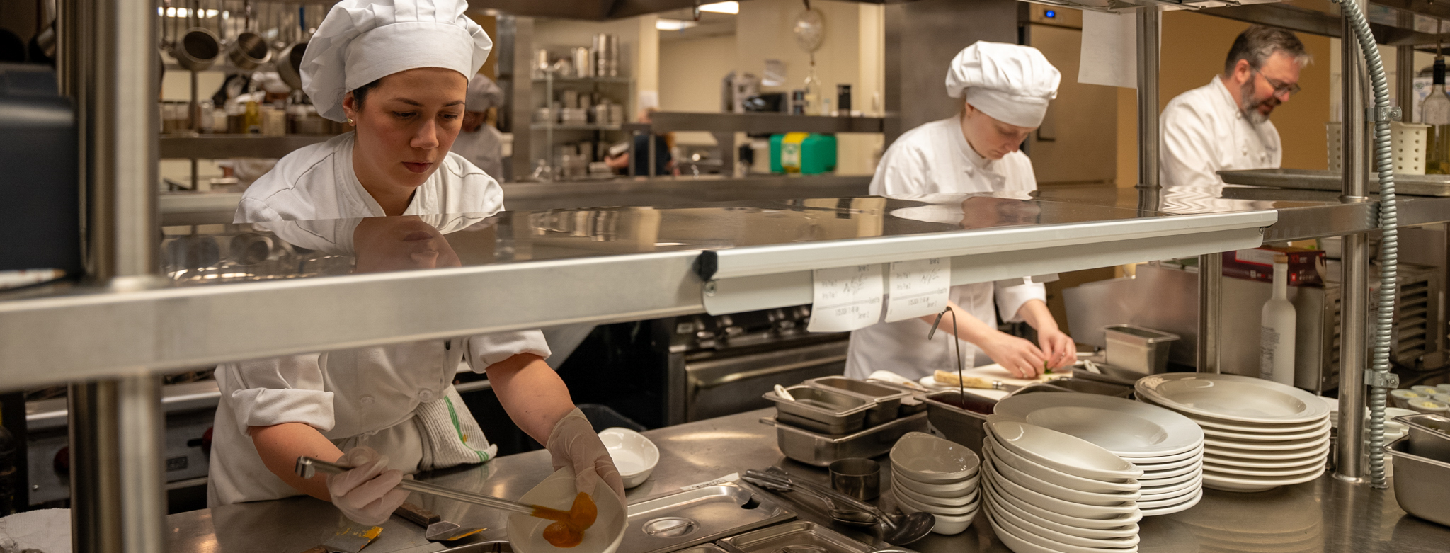 Culinary Arts Students working with instructor in the kitchen