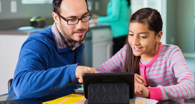 Father and daughter looking at a tablet