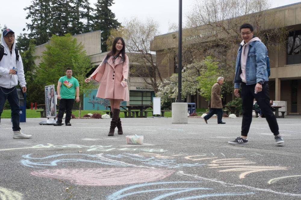 Students in the courtyard doing chalk art