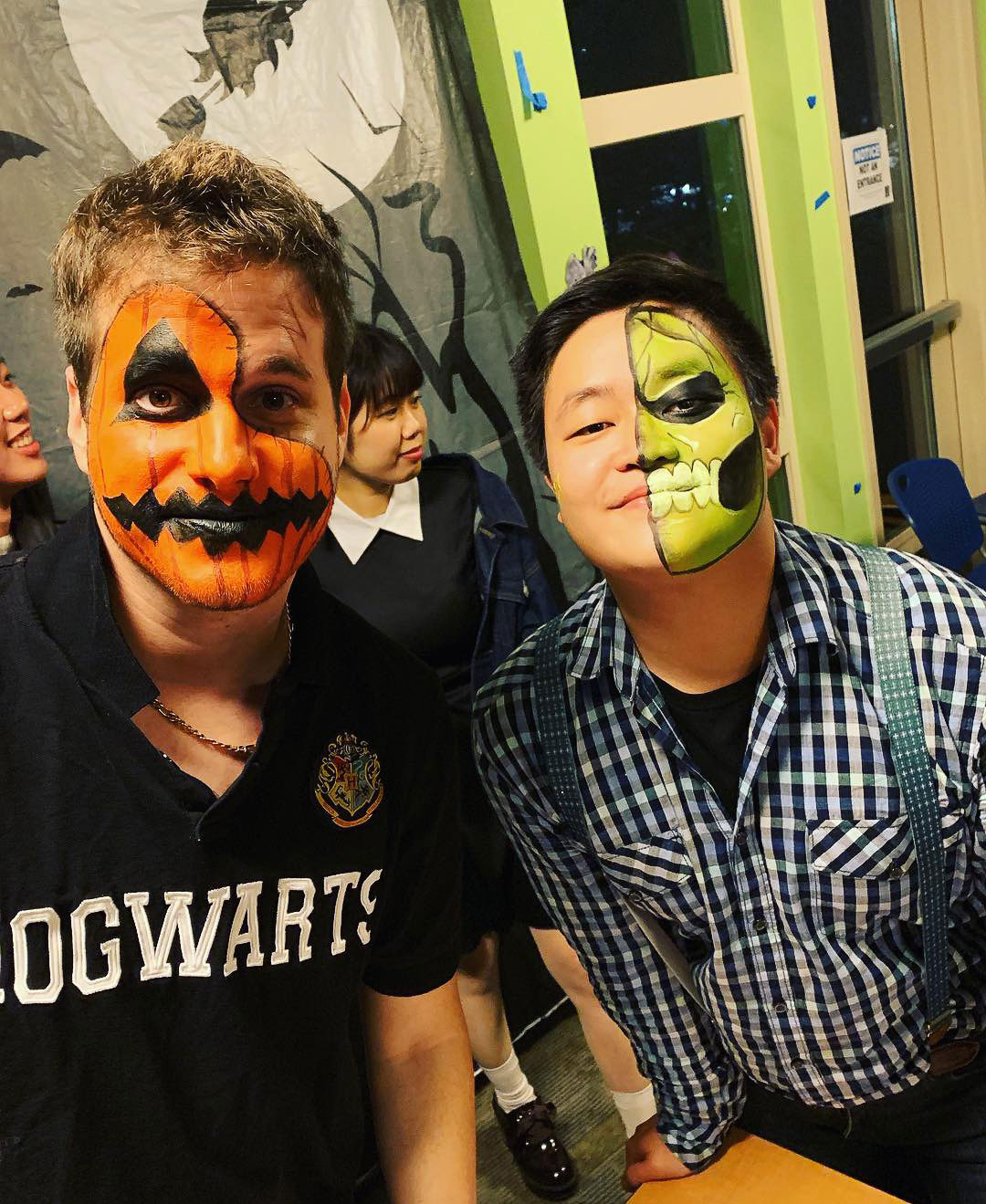 Two students with faces painted at the Housing Halloween event