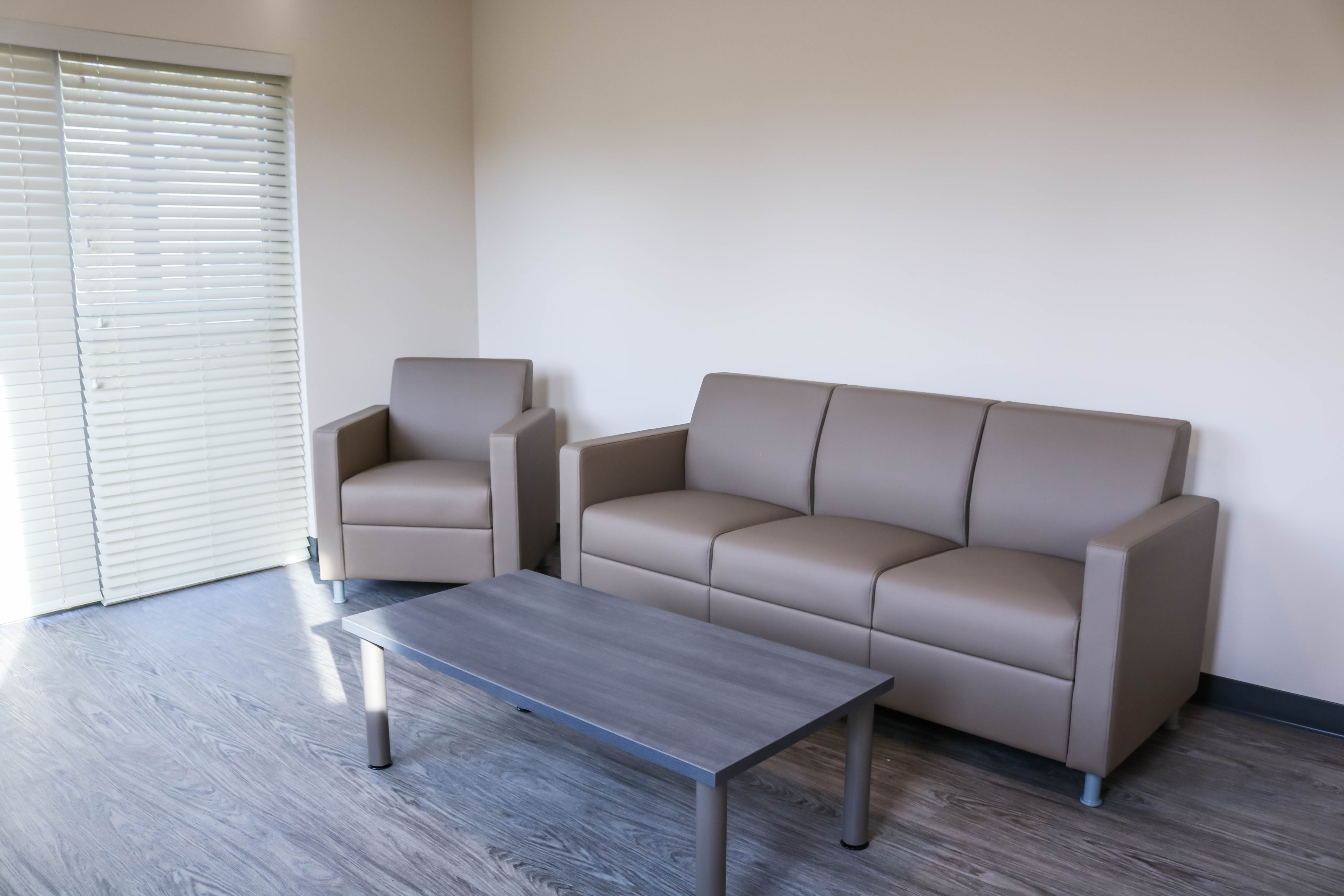 Living Room in Triton Court Unit Unit showing the living room area including a coffee table, three-seater couch and one arm chair couch