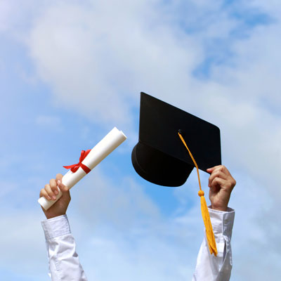 student holding a diploma and a cap